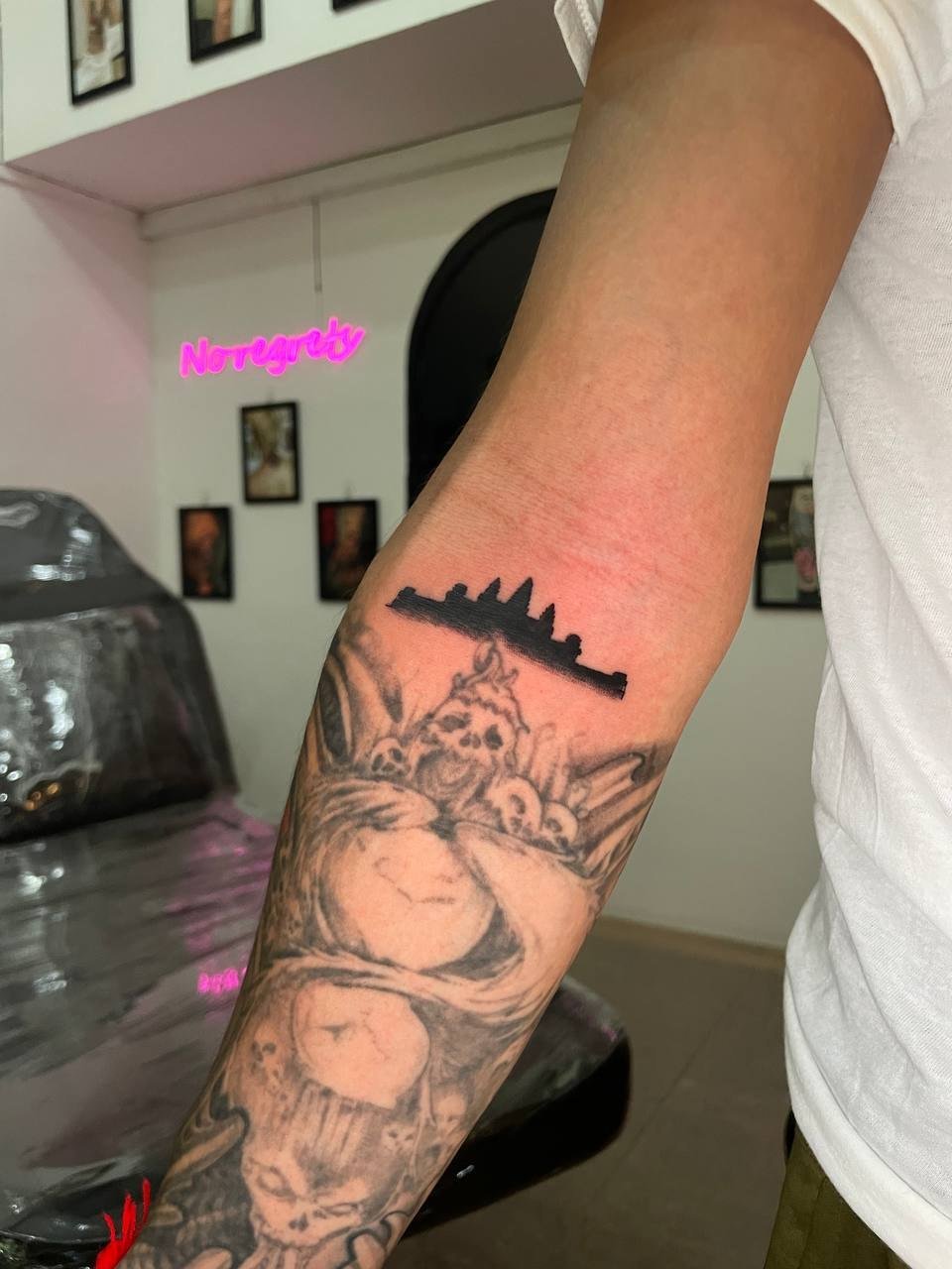 A solid black silhouette of Angkor Wat above the elbow. Tattoo by Edboi