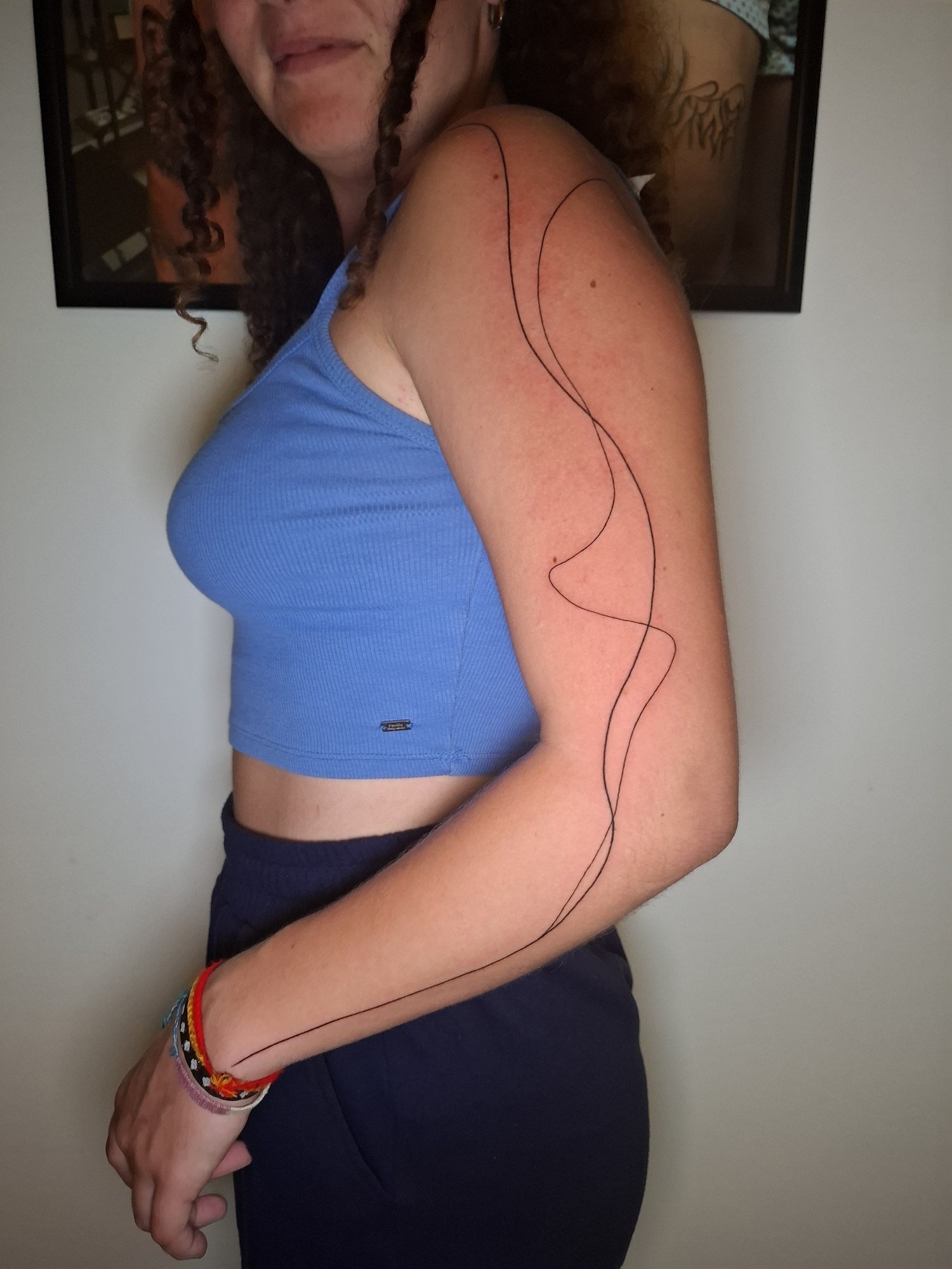 Two long fine black lines flowing from the shoulder to the wrist. Tattoo by Edboi