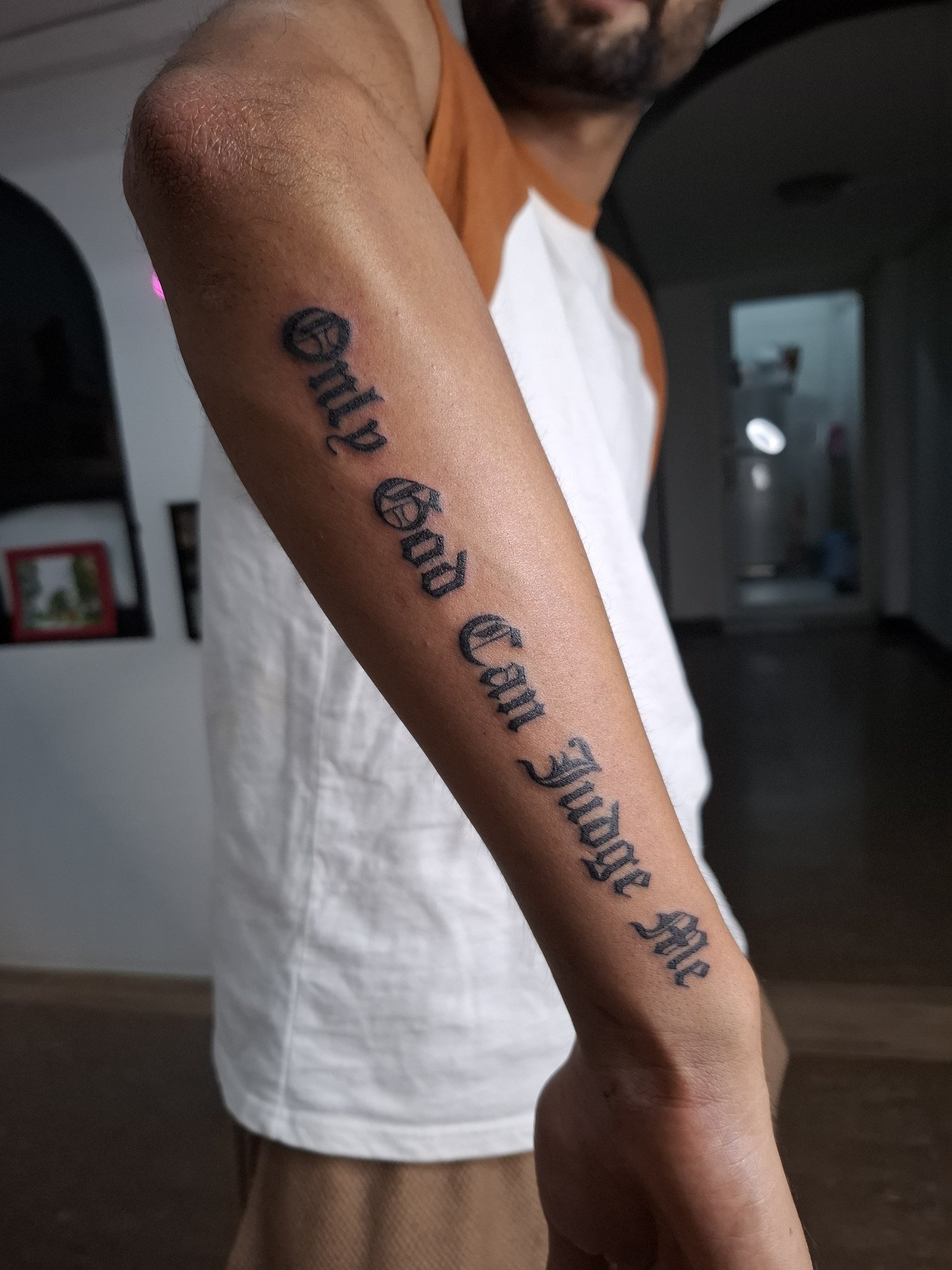 A long line of bold gothic lettering along the forearm. Tattoo by Edboi