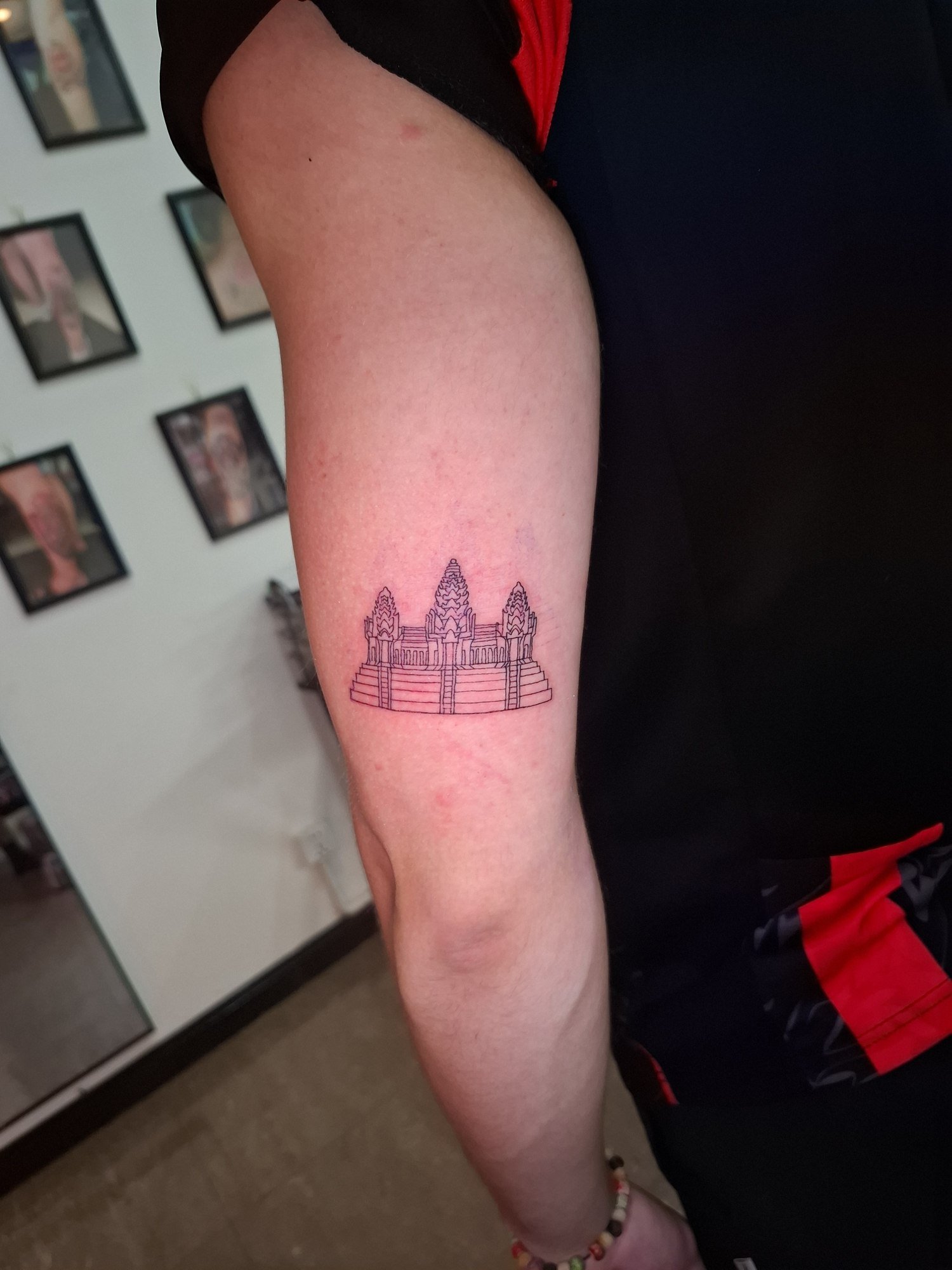 Detailed Angkor Wat towers in black linework on the forearm. Tattoo by Edboi