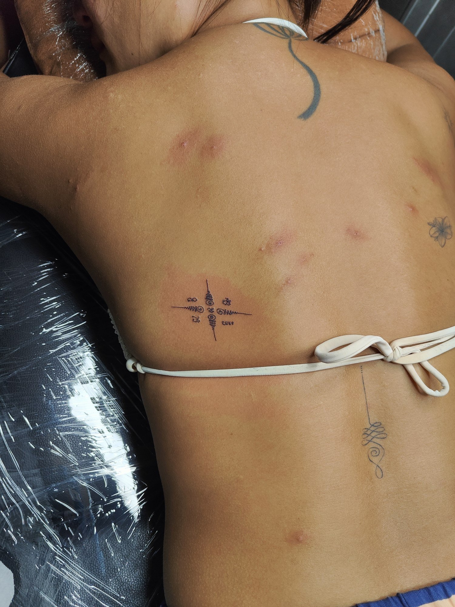A small geometric ornament with fine black lines on the side of the back. Tattoo by Edboi
