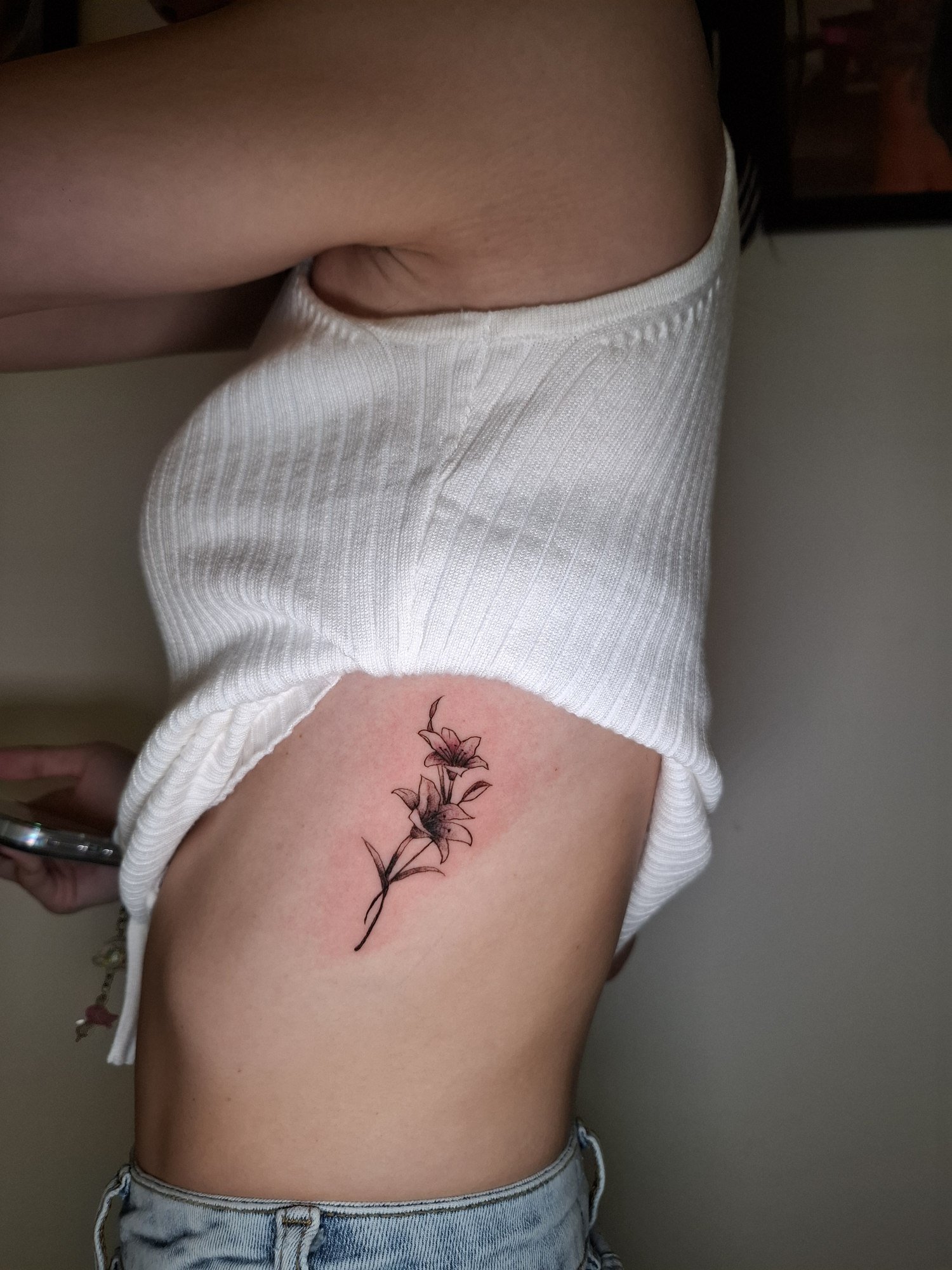 Two delicate lilies with fine stems and shaded petals on the ribs. Tattoo by Edboi