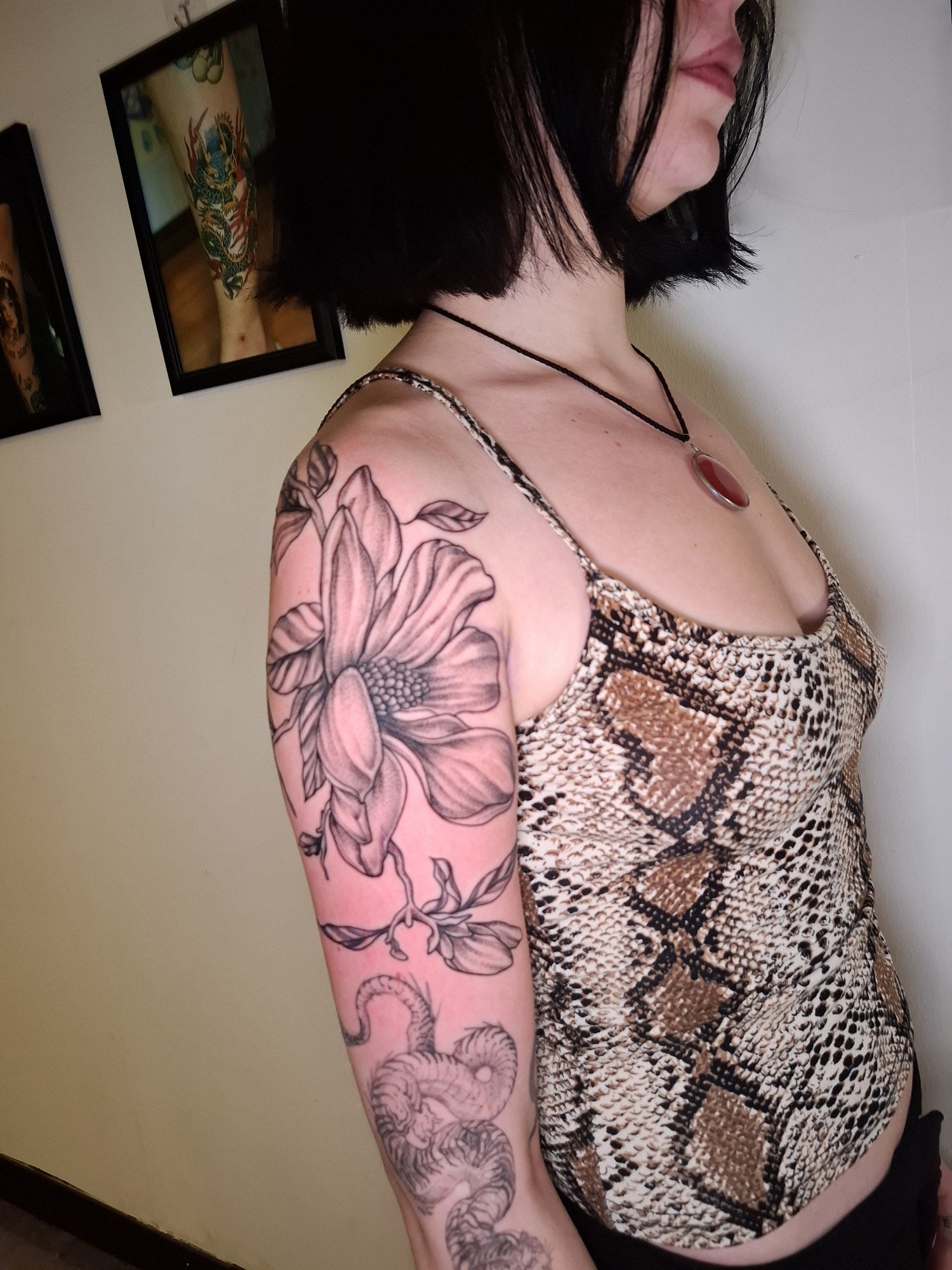 A large lily with shaded petals and flowing leaves on the shoulder and upper arm. Tattoo by Edboi