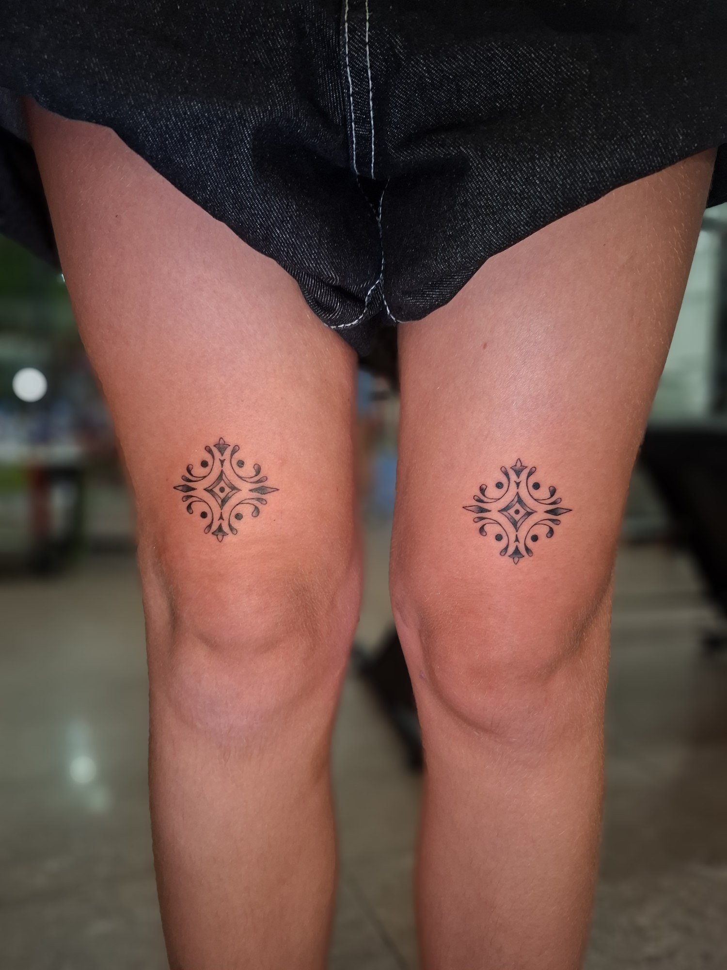Two small symmetrical ornaments above the knees. Tattoo by Edboi