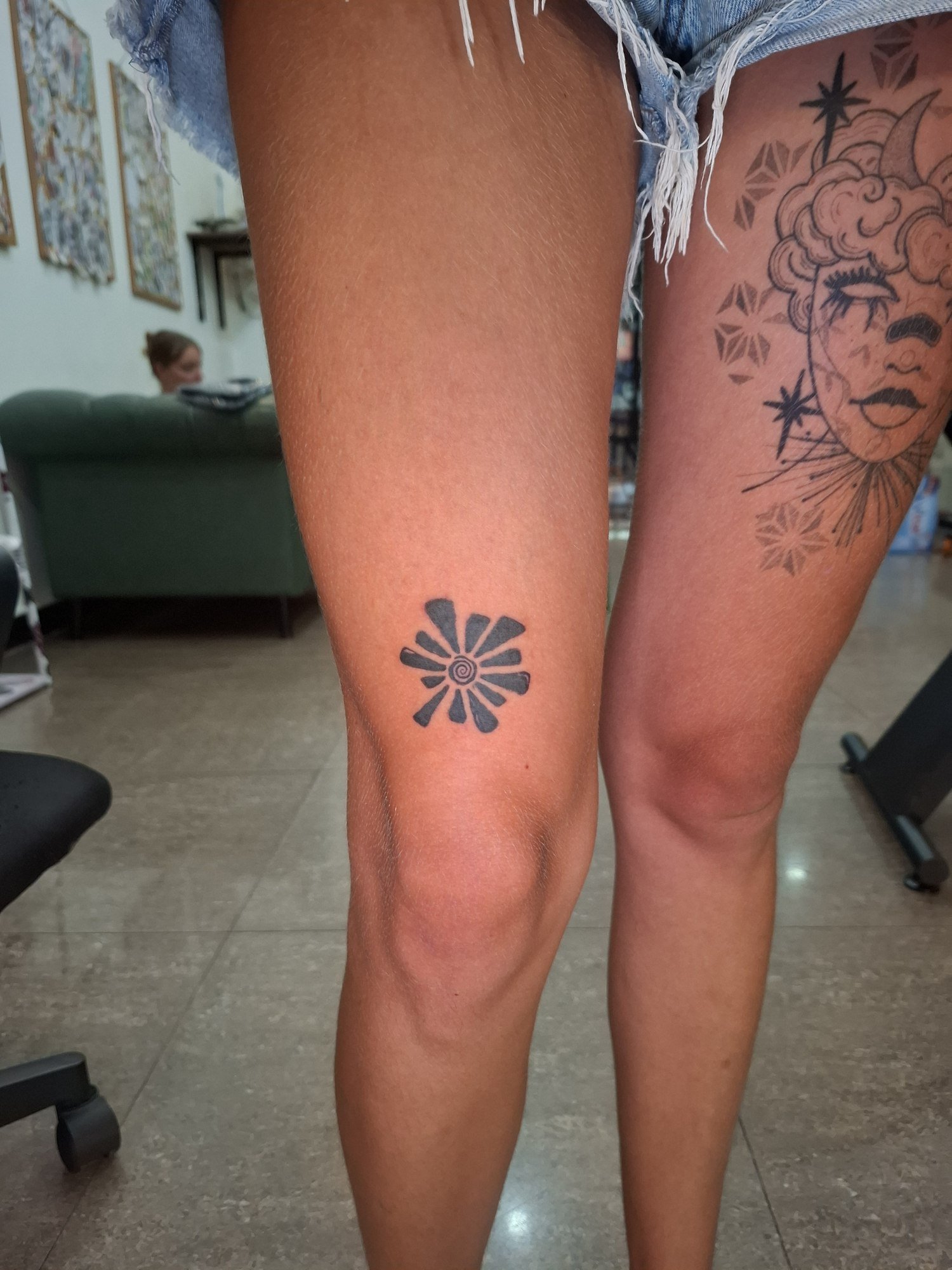 A small black petal-shaped ornament above the knee. Tattoo by Edboi