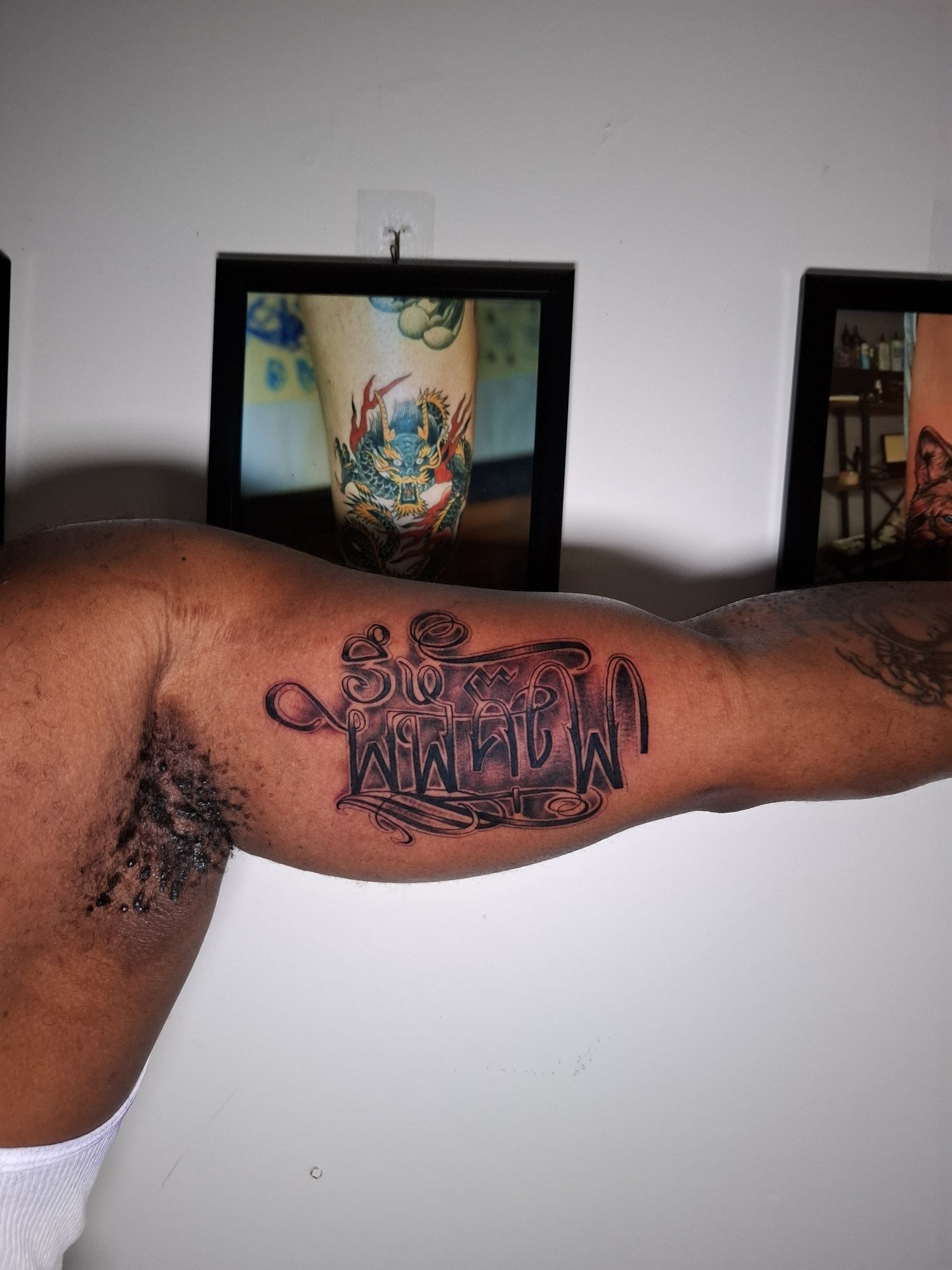 Bold ornamental Khmer lettering with shaded details on the inner upper arm. Tattoo by Edboi