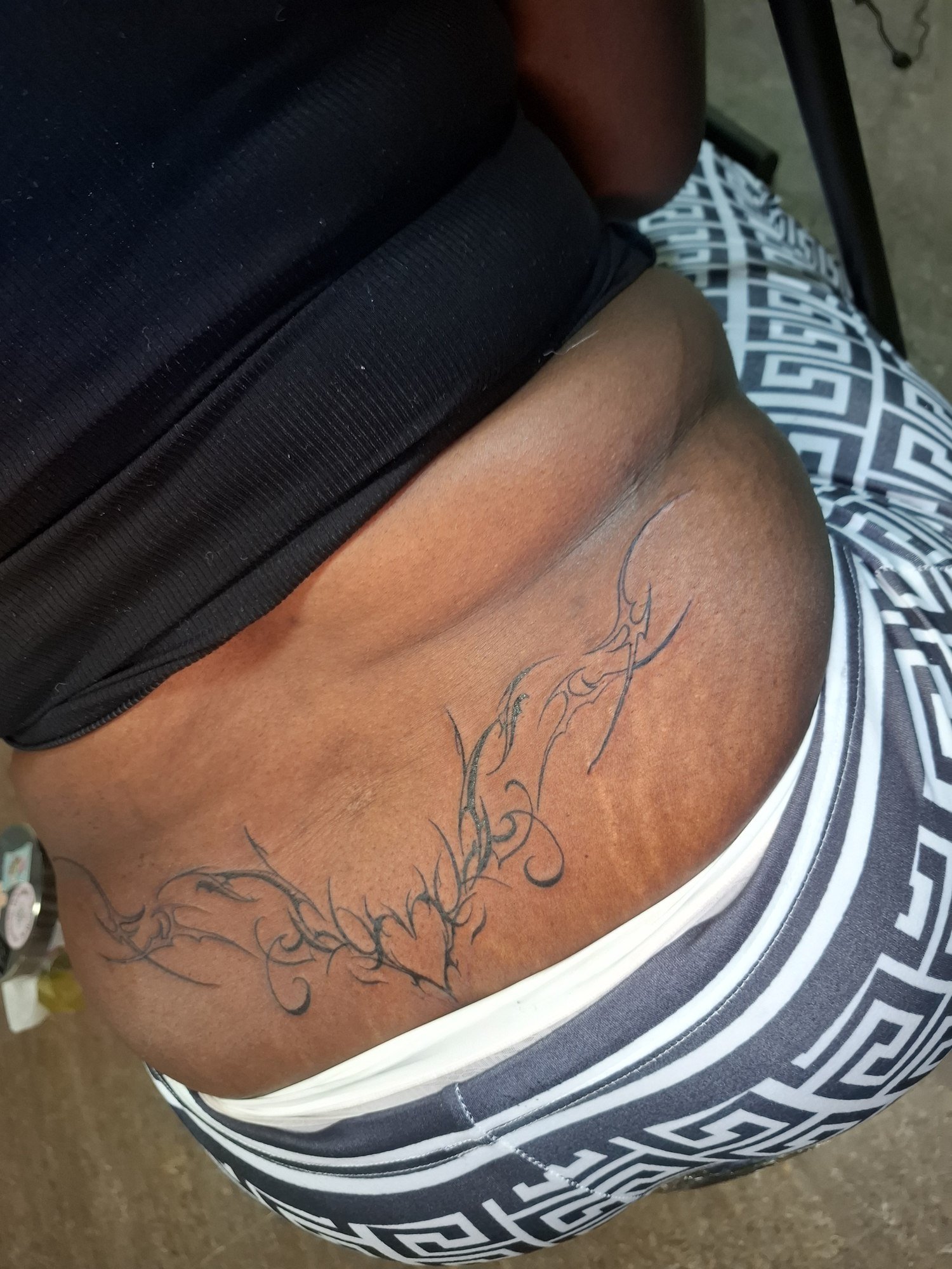 An elongated tribal composition across the lower back. Tattoo by Edboi