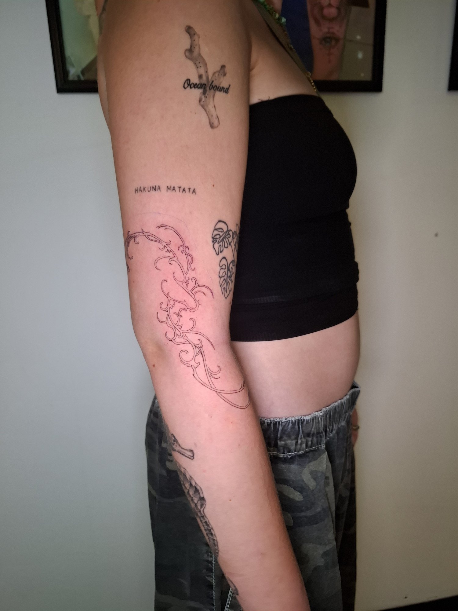 Flowing red tribal outlines along the arm. Tattoo by Edboi