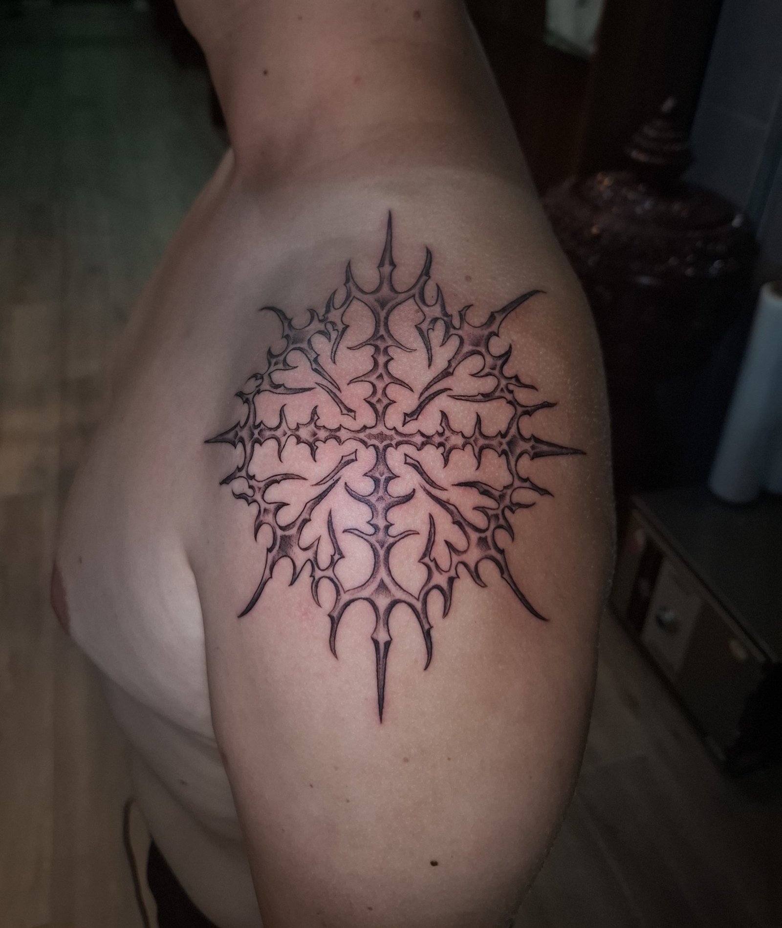 A symmetrical intricate tribal ornament on the shoulder. Tattoo by Edboi