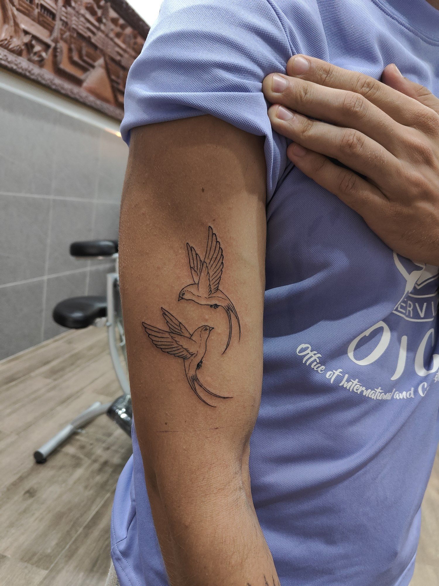 Two birds with flowing wings. Tattoo by Leak